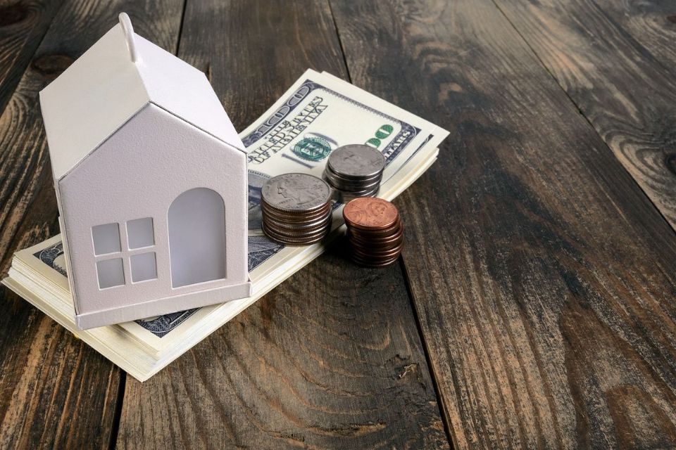 a mini house model and money bills